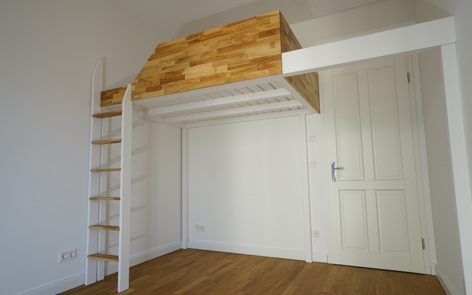 Schwebendes Hochbett mit einem integrierten Lattenrost in weiß, einer Vollholz Eiche Reling und Eiche Leiterstufen geölt. Nutzen sie den stabilen Trägerbalken auch zur Befestigung eines Hängesacks.